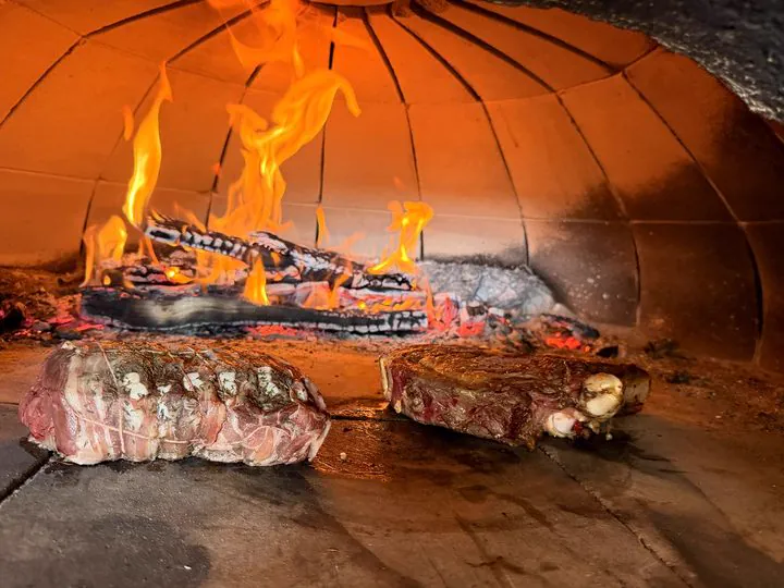 Le four à bois : la côte de bœuf et le châteaubriand devant les flammes