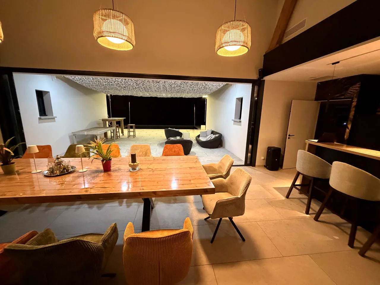 Grande table et salon ouverts sur la terrasse, le soir